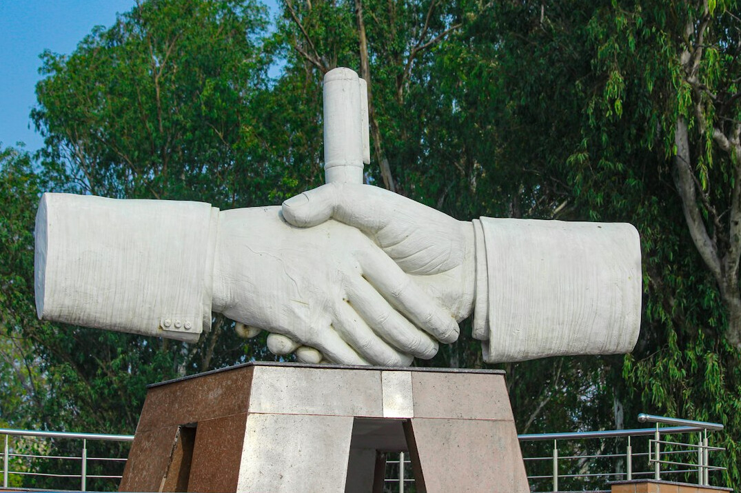 Two business partners from different countries shaking hands over a table