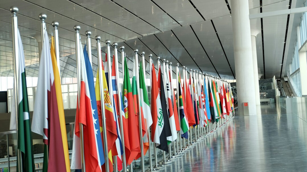 European and Asian business delegates sitting across a negotiation table